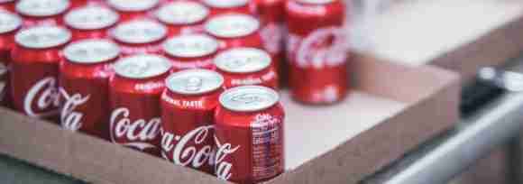 Pack of Coca-Cola cans in a cardboard box, refreshing soft drinks for any occasion.