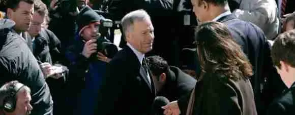 Politician engaging with crowd at a public event, media capturing moments for news coverage.