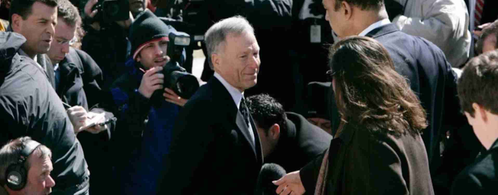 Politician engaging with crowd at a public event, media capturing moments for news coverage.