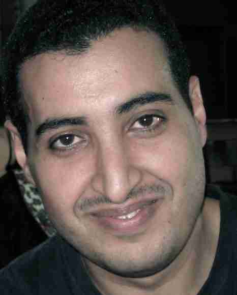 Close-up portrait of a smiling man with dark hair and eyes, emphasizing confidence and personal growth.