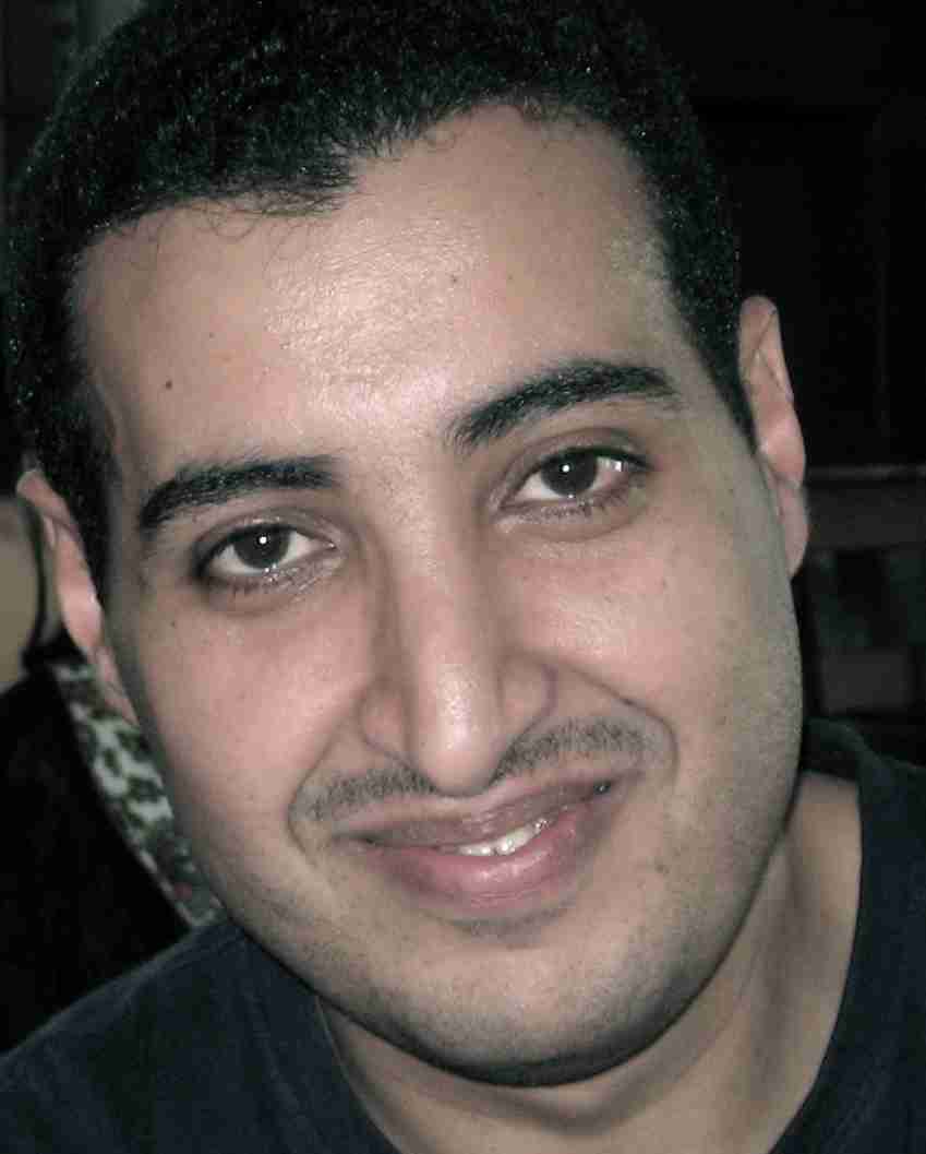 Close-up portrait of a smiling man with dark hair and eyes, emphasizing confidence and personal growth.