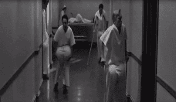 Medical staff attending to patient in hospital corridor for testicular health check.