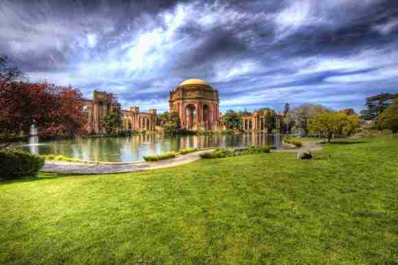 Ancient palace surrounded by a serene lake and vibrant gardens under a dramatic sky. Perfect for exp.