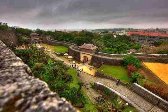 Historic Chinese city wall with watchtowers and lush greenery.