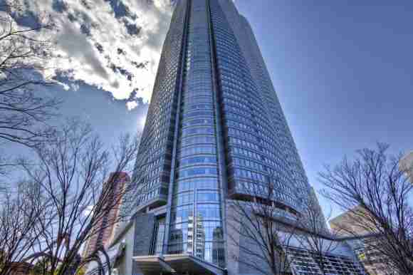Modern glass skyscraper reflecting the sky and clouds.